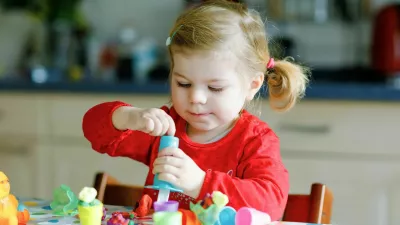 Adorable cute little toddler girl with colorful clay. Healthy baby child playing and creating toys from play dough. Small kid molding modeling clay and learning.