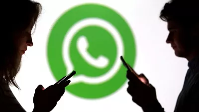 FILE PHOTO: Teenagers pose for a photo while holding smartphones in front of a Whatsapp logo in this illustration taken September 11, 2025. REUTERS/Dado Ruvic/Illustration/File Photo