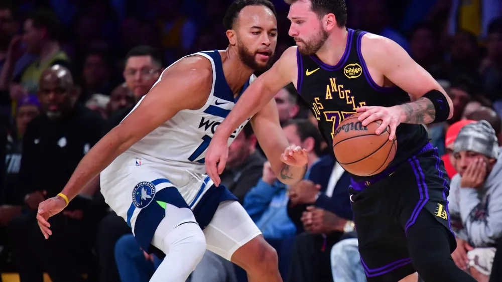Mar 10, 2026; Los Angeles, California, USA; Los Angeles Lakers guard Luka Doncic (77) moves the ball against Minnesota Timberwolves forward Kyle Anderson (12) during the second half at Crypto.com Arena. Mandatory Credit: Gary A. Vasquez-Imagn Images
