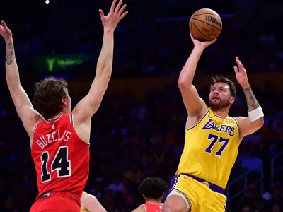 Mar 12, 2026; Los Angeles, California, USA; Los Angeles Lakers guard Luka Doncic (77) shoots against Chicago Bulls forward Matas Buzelis (14) during the first half at Crypto.com Arena. Mandatory Credit: Gary A. Vasquez-Imagn Images