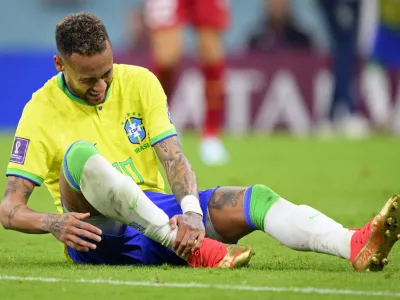 Brazil's Neymar grabs his ankle after an injury during the World Cup group G soccer match between Brazil and Serbia, at the the Lusail Stadium in Lusail, Qatar on Thursday, Nov. 24, 2022. (Laurent Gillieron/Keystone via AP)