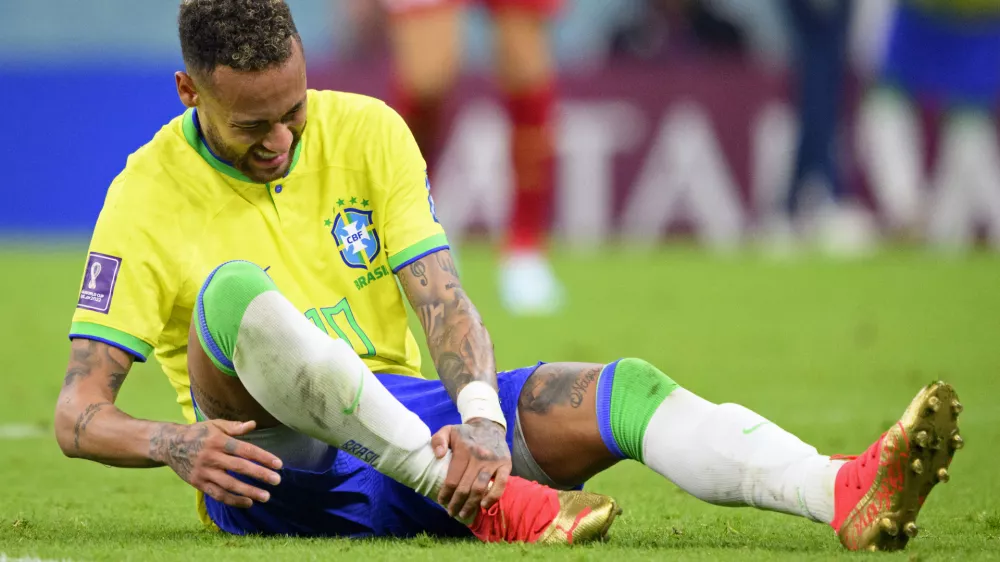 Brazil's Neymar grabs his ankle after an injury during the World Cup group G soccer match between Brazil and Serbia, at the the Lusail Stadium in Lusail, Qatar on Thursday, Nov. 24, 2022. (Laurent Gillieron/Keystone via AP)