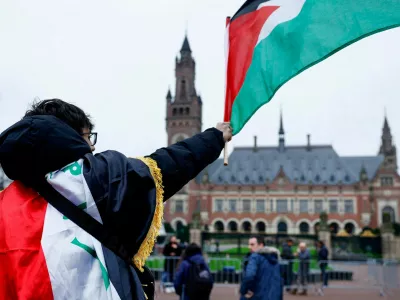 FILE PHOTO: A man waves a Palestinian flag as people protest on the day of a public hearing held by The International Court of Justice (ICJ) to allow parties to give their views on the legal consequences of Israel's occupation of Palestinian territories before eventually issuing a non-binding legal opinion, in The Hague, Netherlands, February 21, 2024. REUTERS/Piroschka van de Wouw/File Photo