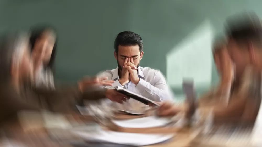 Stress, migraine and motion blur with a business man in a meeting feeling frustrated, tired or overworked. Mental health, anxiety and headache with an exhausted male employee suffering from fatigue / Foto: Jacob Wackerhausen Getty Images
