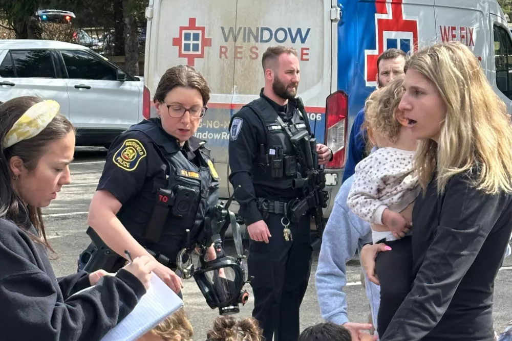 A woman gathers children as law enforcement respond to a call at Temple Israel synagogue in West Bloomfield Township, Mich. (AP Photo/Corey Williams)