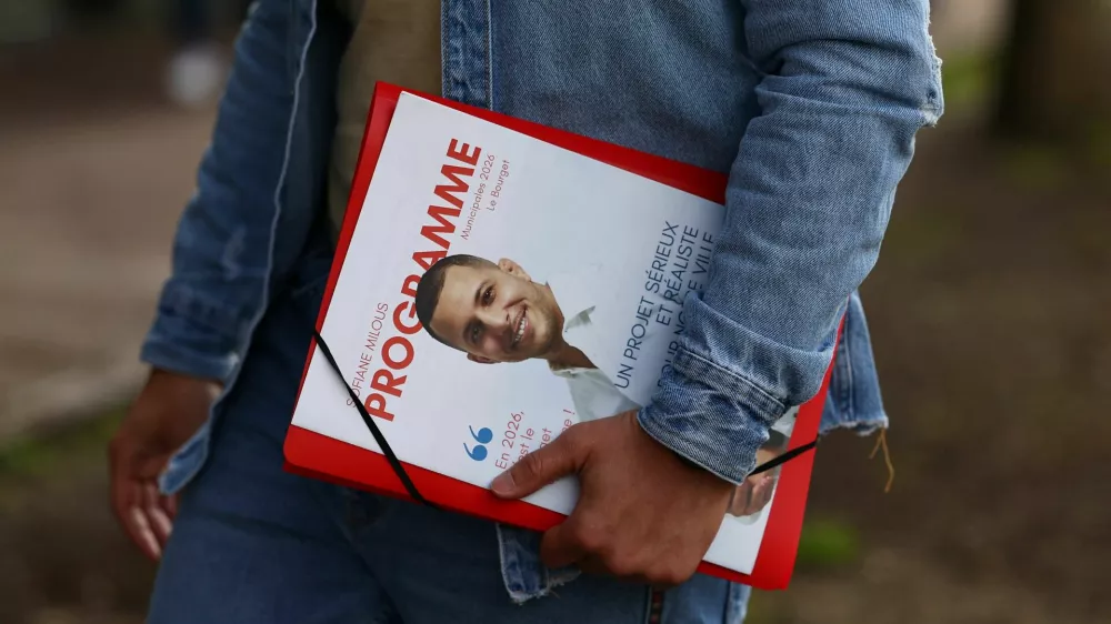 Municipal candidate Sofiane Milous, running on a green ticket in France's upcoming local elections and campaigning against a data centre, holds leaflets as he goes door to door to speak to voters in Le Bourget, north of Paris, France, March 11, 2026. REUTERS/Abdul?Saboor