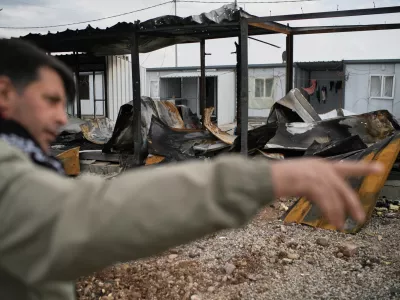 Rebaz Sharifi, a unit commander in the armed wing of the Kurdish-Iranian opposition group Kurdistan Freedom Party (PAK), shows areas damaged in Iranian drone attacks last week at a military base on the outskirts of Erbil, Iraq, Wednesday, March 11, 2026. (AP Photo/Leo Correa)