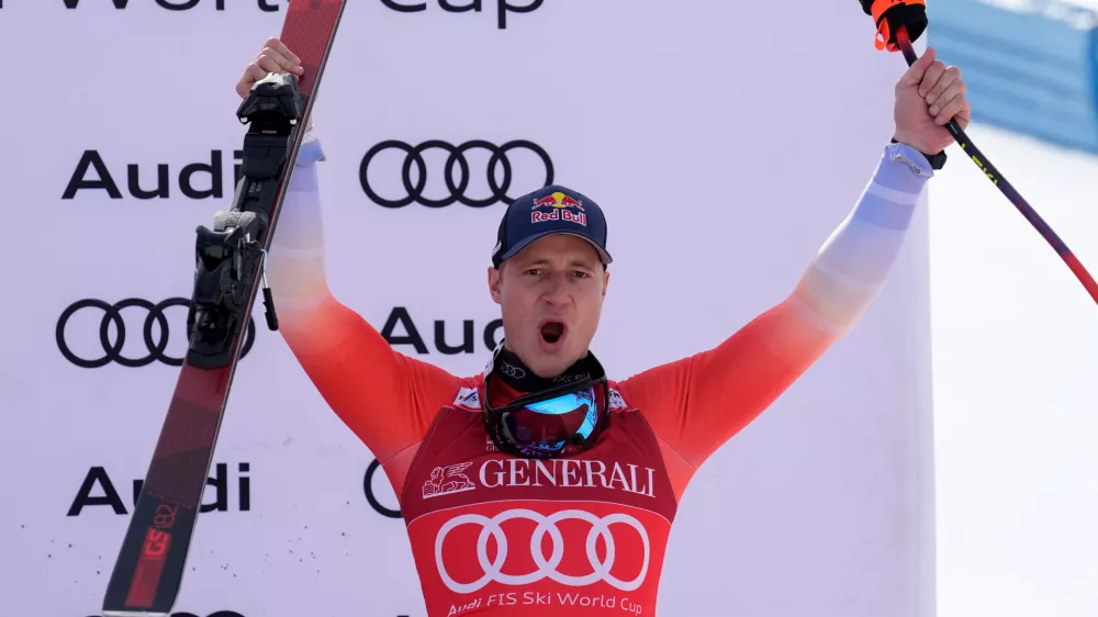 Switzerland's Marco Odermatt celebrates on the podium after taking third place in an alpine ski, men's World Cup downhill race, in Courchevel, France, Friday, March 13, 2026. (AP Photo/Giovanni Auletta)