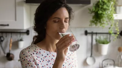 Pure pleasure. Thirsty millennial female drink swallow cool clear mineral aqua from glass at home kitchen feel delight. Young woman enjoy crystal filtered potable water with closed eyes relieve stress / Foto: Fizkes Getty Images