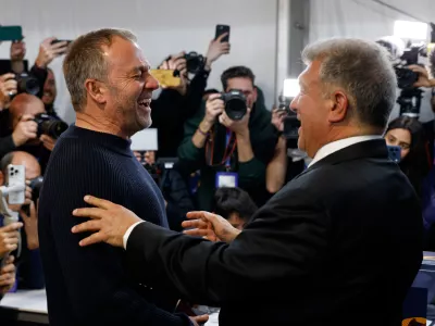 Joan Laporta reacts as he greets Barcelona's head coach Hansi Flick, left, after the voting for the election to be president of FC Barcelona in Barcelona, Spain, Sunday, March 15, 2026. (AP Photo/Joan Monfort)