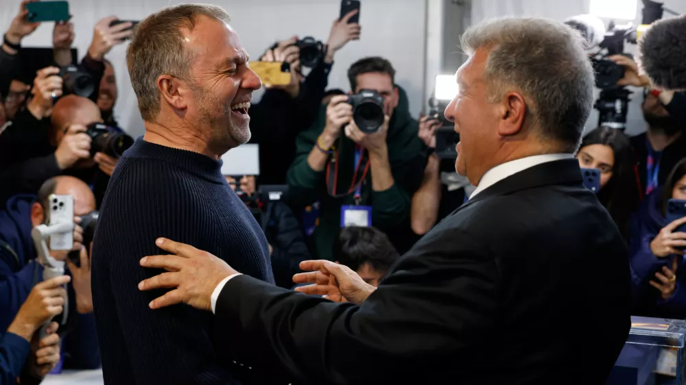 Joan Laporta reacts as he greets Barcelona's head coach Hansi Flick, left, after the voting for the election to be president of FC Barcelona in Barcelona, Spain, Sunday, March 15, 2026. (AP Photo/Joan Monfort)