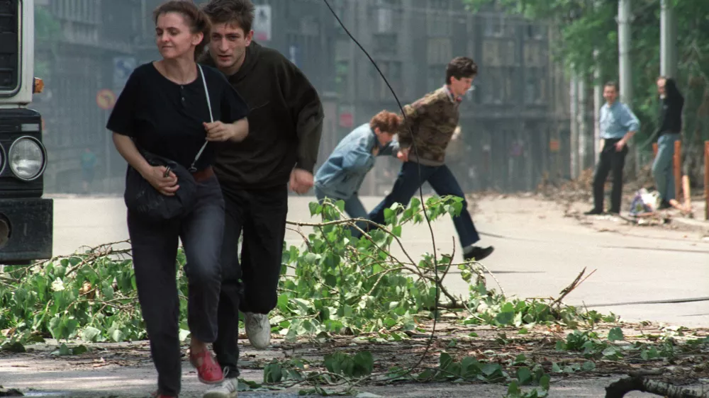 (FILES) Sarajevo residents run through an intersection known for sniper activity after a shell fell in the center of the city on June 20, 1992. Milan's prosecutor office has opened an investigation into "weekend snipers," many of them Italians, who during the siege of Sarajevo in the early 1990s allegedly paid the Serbian army to shoot civilians, according to the Italian press and the former mayor of Sarajevo. These "war tourists," mostly wealthy, gun-loving, far-right sympathizers, gathered in Trieste, northern Italy, before being taken to the hills surrounding Sarajevo, according to La Repubblica newspaper.,Image: 1052225522, License: Rights-managed, Restrictions:, Model Release: no