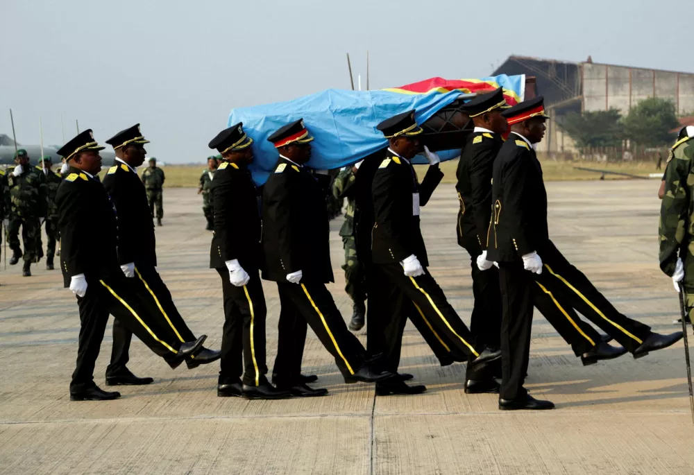 FILE PHOTO: Guards of honour members carry a coffin that contains the only known remains, a tooth of the murdered Congolese independence hero Patrice Lumumba, after he was returned to his family by the Belgian government at Airport in Kinshasa, Democratic Republic of Congo June 27, 2022. REUTERS/Justin Makangara/File Photo