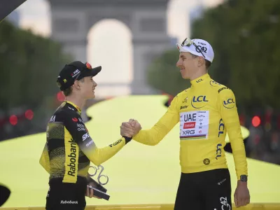 Denmark's Jonas Vingegaard, second placed, left, greets Slovenia's Tadej Pogacar, the Tour de France winner, during the presentation ceremony for the Tour de France on the Champs-Elysees in Paris, France, Sunday, July 27, 2025. (Bernard Papon, Pool Photo via AP)