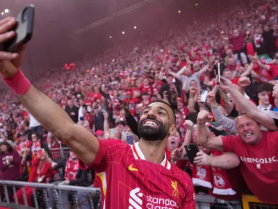 FILE - Liverpool's Mohamed Salah celebrates by taking a selfie after winning the English Premier League soccer match between Liverpool and Tottenham Hotspur and clinching the Premier League title at Anfield in Liverpool, England, April 27, 2025. (AP Photo/Jon Super, File)