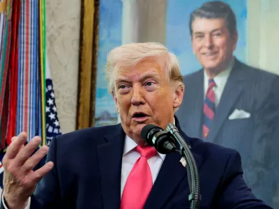 U.S. President Donald Trump speaks, with a portrait of former U.S. President Ronald Reagan in the background, as he attends Markwayne Mullin's swearing-in as Department of Homeland Security (DHS) Secretary, at the White House in Washington, D.C., U.S., March 24, 2026. REUTERS/Evan Vucci   TPX IMAGES OF THE DAY