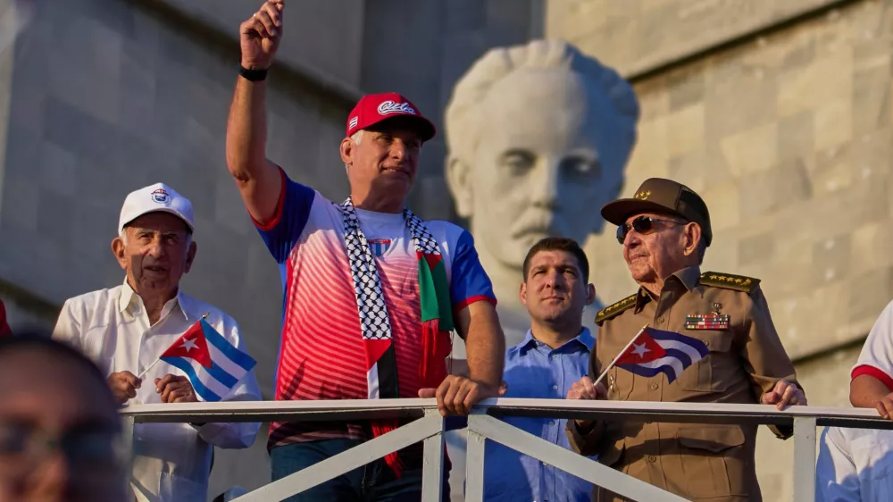 FILE - Cuba's President Miguel Diaz-Canel holds up a Cuban flag as he watches the May Day parade next to Raul Castro, second from right, and Raul Castro's grandson, Raul Guillermo Rodriguez Castro, at Revolution Square in Havana, May 1, 2025. (AP Photo/Ramon Espinosa, File)