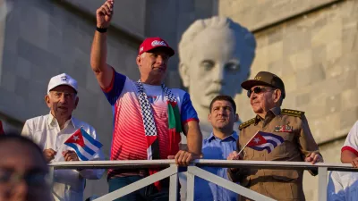 FILE - Cuba's President Miguel Diaz-Canel holds up a Cuban flag as he watches the May Day parade next to Raul Castro, second from right, and Raul Castro's grandson, Raul Guillermo Rodriguez Castro, at Revolution Square in Havana, May 1, 2025. (AP Photo/Ramon Espinosa, File)