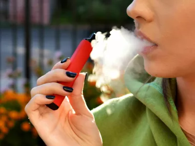 beautiful brunette smoke electronic cigarette in public places / Foto: Igor Ilkov