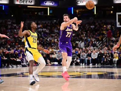 Mar 25, 2026; Indianapolis, Indiana, USA; Los Angeles Lakers guard Luka Doncic (77) passes the ball away from Indiana Pacers guard Aaron Nesmith (23) during the second half at Gainbridge Fieldhouse. Mandatory Credit: Marc Lebryk-Imagn Images