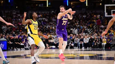 Mar 25, 2026; Indianapolis, Indiana, USA; Los Angeles Lakers guard Luka Doncic (77) passes the ball away from Indiana Pacers guard Aaron Nesmith (23) during the second half at Gainbridge Fieldhouse. Mandatory Credit: Marc Lebryk-Imagn Images