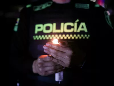 A police officer holds a candle during a tribute to the victims of a military plane crash that occurred shortly after takeoff in Puerto Leguizamo, in Bogota, Colombia, March 25, 2026. REUTERS/Luisa Gonzalez   TPX IMAGES OF THE DAY