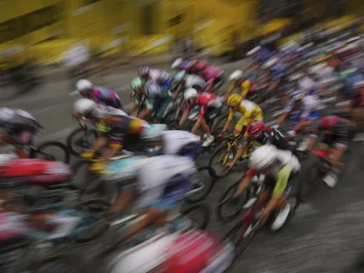 The pack with Slovenia's Tadej Pogacar, wearing the overall leader's yellow jersey, rides during the twenty-first stage of the Tour de France cycling race over 132.3 kilometers (82.1 miles) with start in Mantes-la-Ville and finish on the Champs-Elysees in Paris, France, Sunday, July 27, 2025. (AP Photo/Thibault Camus)