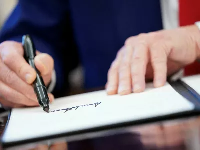 FILE PHOTO: U.S. President Donald Trump writes his signature, as he signs executive orders and proclamations in the Oval Office at the White House in Washington, D.C., U.S., April 9, 2025. REUTERS/Nathan Howard/File Photo/File Photo