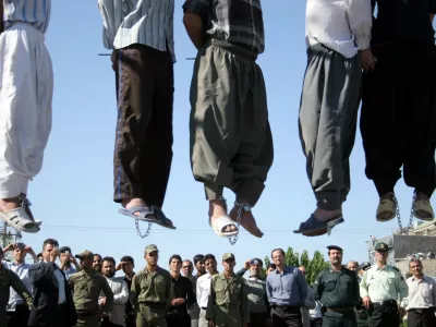 ** GRAPHIC CONTENT ** Iranian police officers and others view the scene as five convicted criminals are hanged in a neighborhood of Mashad, 1,000 kilometers (620 miles) northwest of Tehran, Iran, Wednesday Aug. 1, 2007. In the second round of collective executions in ten days, Iran on Wednesday publicly hanged 7 criminals convicted on various charges of rape, robbery and kidnapping, according to reports on the official web-site of state broadcasting company. (AP Photo/Halabisaz)