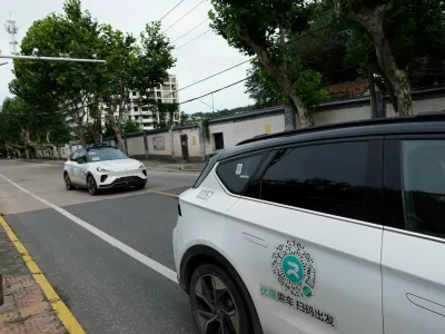 FILE PHOTO: A driverless car by Apollo Go, Baidu's robotaxi service, drives past another Apollo Go robotaxi parked on the side of a road, in Wuhan, Hubei province, China July 19, 2024. REUTERS/Ethan Wang/File Photo