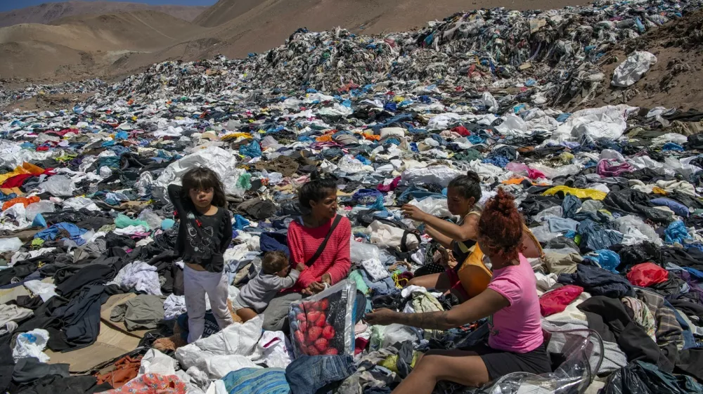 Women search for used clothes amid tons discarded in the Atacama desert, in Alto Hospicio, Iquique, Chile, on September 26, 2021. EcoFibra, Ecocitex and Sembra are circular economy projects that have textile waste as their raw material. The textile industry in Chile will be included in the law of Extended Responsibility of the Producer (REP), forcing clothes and textiles importers take charge of the waste they generate.,Image: 642069771, License: Rights-managed, Restrictions: TO GO WITH AFP STORY BY PAULA BUSTAMANTE, Model Release: no