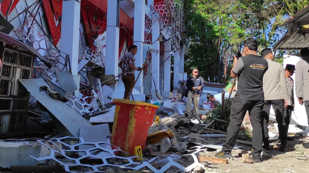 Police officers inspect a damaged building following an earthquake in Manado, North Sulawesi, Indonesia, Thursday, April 2, 2026. (AP Photo/Tonny Rarung)