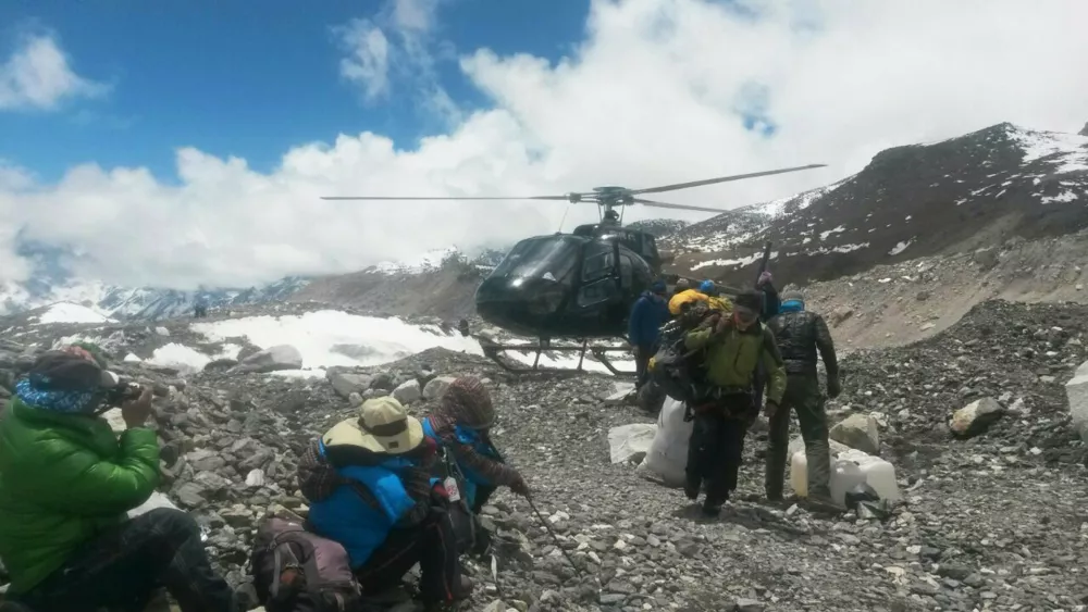 A rescue chopper lands carrying people from higher camps to Everest Base Camp, Nepal, Monday, April 27, 2015. An avalanche on Saturday, set off by the massive earthquake that struck Nepal, left more than a dozen people dead and dozens more injured. (AP Photo/Nima Namgyal Sherpa)