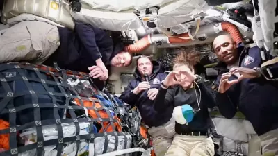 This image taken from video provided by NASA shows the Artemis II crew Commander Reid Wiseman, second from left, thanking the families of the crew while speaking with NASA Mission Control via video conference from the moon's orbit as Canadien astronaut and mission specialist Jeremy Hansen, far left, looks on and mission specialist Christina Koch and pilot Victor Glover, far right, make hearts with their hands Thursday, April 2, 2026. (NASA via AP)
