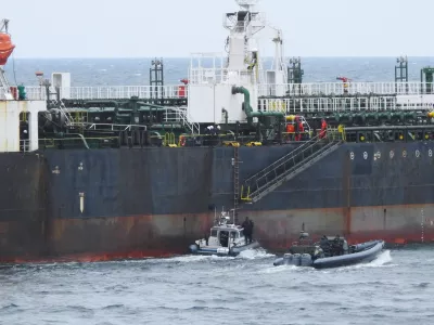 In this photo provided by the Swedish Coast Guard, personnel board a tanker suspected of causing an oil spill in the Baltic Sea, Friday, April 3, 2026. (Swedish Coast Guard via AP)