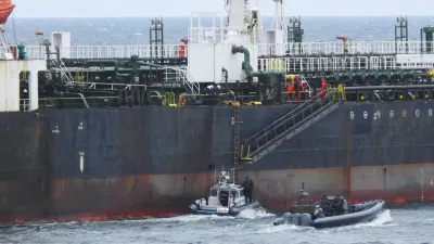 In this photo provided by the Swedish Coast Guard, personnel board a tanker suspected of causing an oil spill in the Baltic Sea, Friday, April 3, 2026. (Swedish Coast Guard via AP)