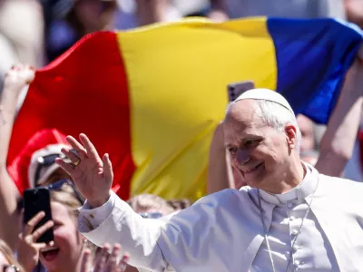 Faithful hold a Romanian flag as Pope Leo XIV waves from the popemobile after delivering his "Urbi et Orbi" (To the city and the world) message, on Easter Sunday, at the Vatican, April 5, 2026. REUTERS/Remo Casilli