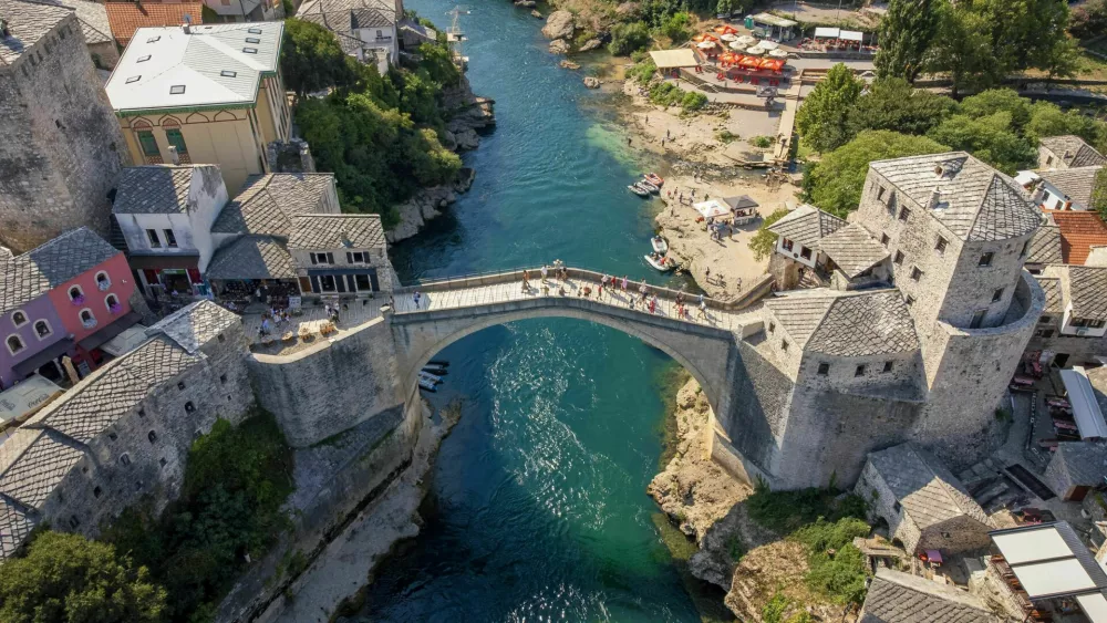 Top view of famous Mostar bridge. Aerial landscape view of tourist attraction with city background in summer / Foto: Ponta Shots