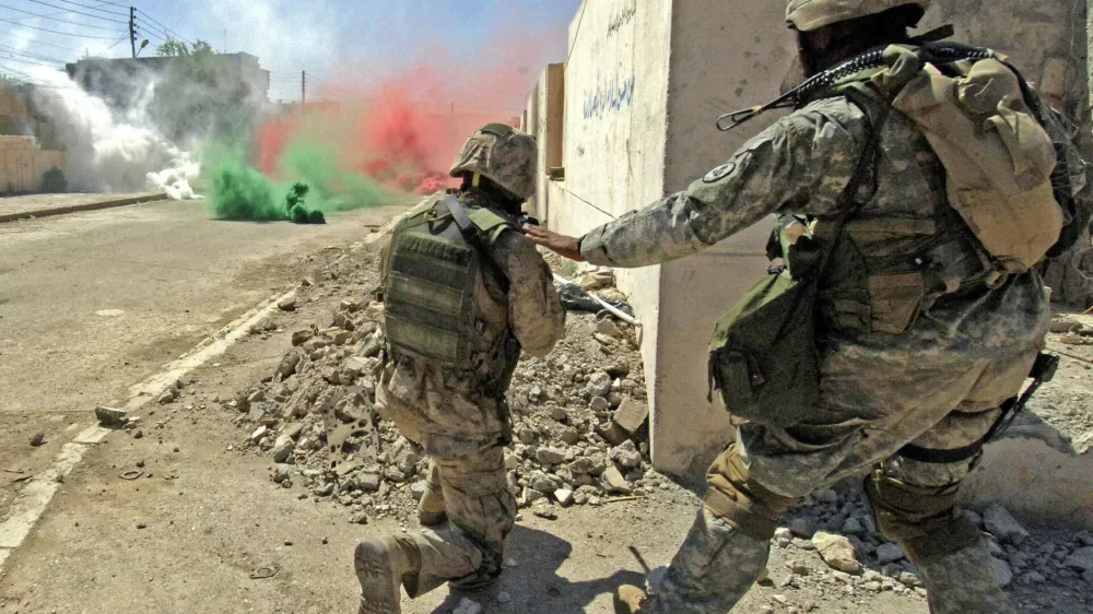 U.S. marines from the I Marine Expeditionary Force take their position near colored smokes to cover their movement during a firefight with insurgents in Ramadi, 100 km (60 miles), west of Baghdad, in this photo taken June 15, 2006 and released June 17, 2006.  NO SALES  NO ARCHIVES.  FOR EDITORIAL USE ONLY     REUTERS/Petty Officer 2nd Class Samuel C. Peterson/Handout  (IRAQ)