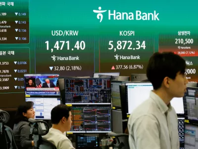 Currency dealers work as an electronic board displays the exchange rate between the U.S. dollar, the Korea Composite&nbsp;Stock&nbsp;Price Index (KOSPI), and South Korean won and the Korea Securities Dealers Automated Quotations (KOSDAQ), along with a news broadcast on a two-week ceasefire in the U.S.-Israel conflict with Iran, at the dealing room of a bank in&nbsp;Seoul, South Korea, April 8, 2026. REUTERS/Kim Soo-hyeon