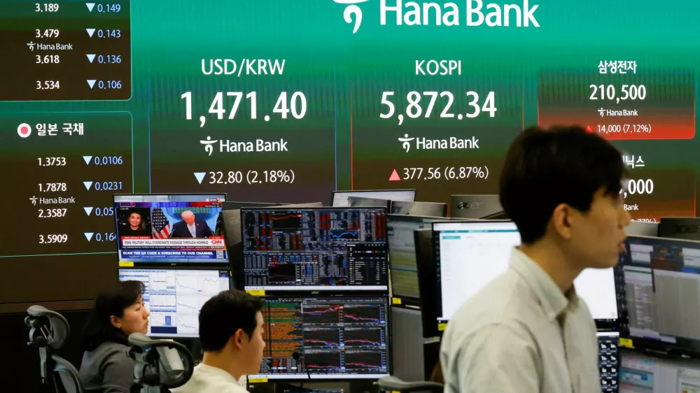 Currency dealers work as an electronic board displays the exchange rate between the U.S. dollar, the Korea Composite&nbsp;Stock&nbsp;Price Index (KOSPI), and South Korean won and the Korea Securities Dealers Automated Quotations (KOSDAQ), along with a news broadcast on a two-week ceasefire in the U.S.-Israel conflict with Iran, at the dealing room of a bank in&nbsp;Seoul, South Korea, April 8, 2026. REUTERS/Kim Soo-hyeon