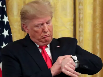 FILE PHOTO: U.S. President Donald Trump checks his watch during an event to celebrate federal judicial confirmations in the East Room of the White House in Washington, D.C., U.S., November 6, 2019. REUTERS/Jonathan Ernst/File Photo