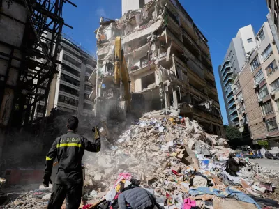 Lebanese civil defense worker gestures to an excavator as they search for victims in the rubbles at the site of a building destroyed in an Israeli airstrike a day earlier in central in Beirut, Lebanon, Thursday, April 9, 2026. (AP Photo/Hussein Malla)