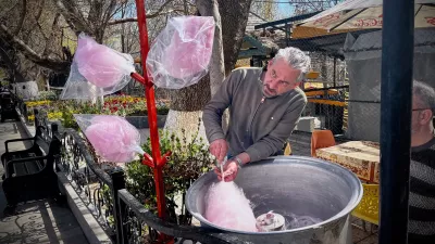 A man spins cotton candy for passersby in a public park near Road 2 in Tabriz, Iran, Thursday, April 9, 2026. (AP Photo/Francisco Seco)