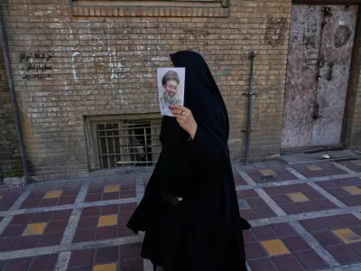 A woman carries a poster depicting Iran's Supreme Leader Ayatollah Mojtaba Khamenei as government supporters gather to mark the 40th day since the killing of his father Supreme Leader Ayatollah Ali Khamenei, in Tehran, Iran, Thursday, April 9, 2026. (AP Photo/Vahid Salemi)