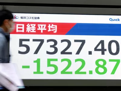 People walk in front of an electronic stock board showing Japan's Nikkei index at a securities firm Monday, March 1, 2026, in Tokyo.(Yohei Fukai/Kyodo News via AP)