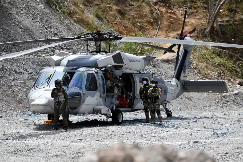 Military personnel stand next to a Mexican Air Force helicopter while, together with rescue teams, they take part in an operation to rescue miner Francisco Zapata Najera, 42, during a search for four miners following a collapse at the Minerales de Sinaloa mine, in the municipality of El Rosario, Sinaloa state, Mexico, April 8, 2026. REUTERS/Stringer