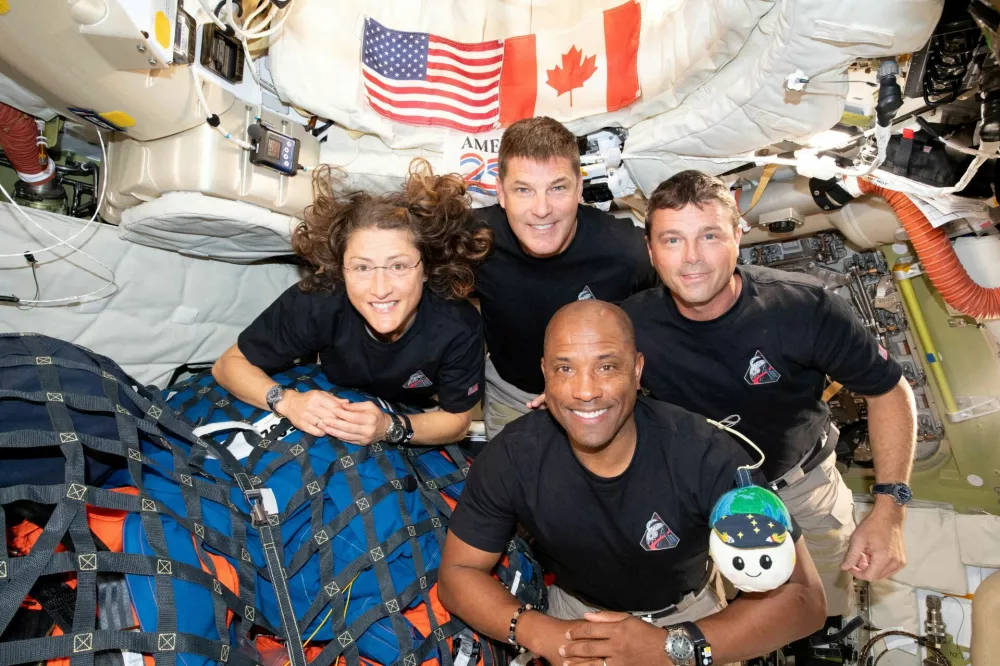 The NASA Artemis II crew, Mission Specialist Christina Koch, Mission Specialist Jeremy Hansen, Commander Reid Wiseman, and Pilot Victor Glover, pose for a group photo inside the Orion spacecraft on their way home following a flyby of the far side of the Moon on April 6, 2026. NASA/Handout via REUTERS THIS IMAGE HAS BEEN SUPPLIED BY A THIRD PARTY. REFILE - CORRECTING DATE FROM "APRIL 6" TO "APRIL 7".  TPX IMAGES OF THE DAY