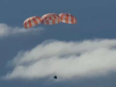 In this image from video provided by NASA, the Artemis II Orion capsule uses parachutes to decelerate for splashdown in the Pacific Ocean, on Friday, April 10, 2026. (NASA via AP)