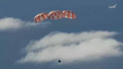 In this image from video provided by NASA, the Artemis II Orion capsule uses parachutes to decelerate for splashdown in the Pacific Ocean, on Friday, April 10, 2026. (NASA via AP)